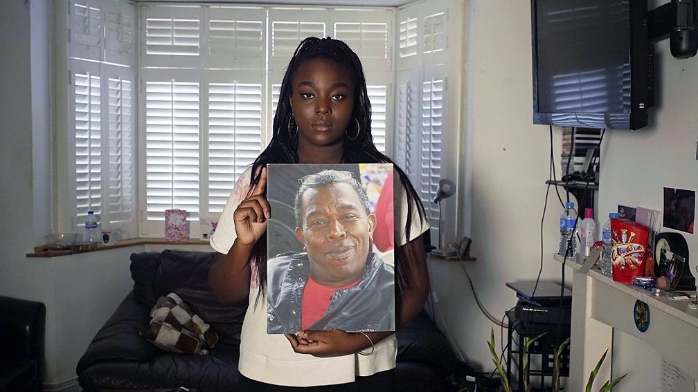 Daughter holding a photo of her father