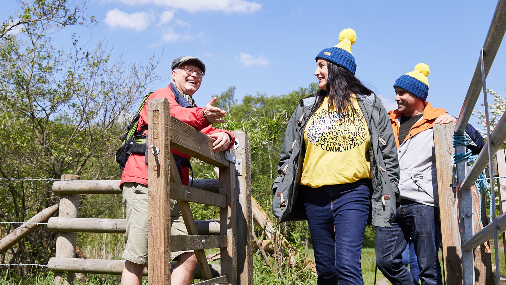 A group of people on a Countryfile Ramble by a mountain lake in Wales.