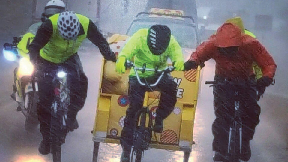 Three riders with the BBC Children in Need rickshaw in a torrential rain storm.