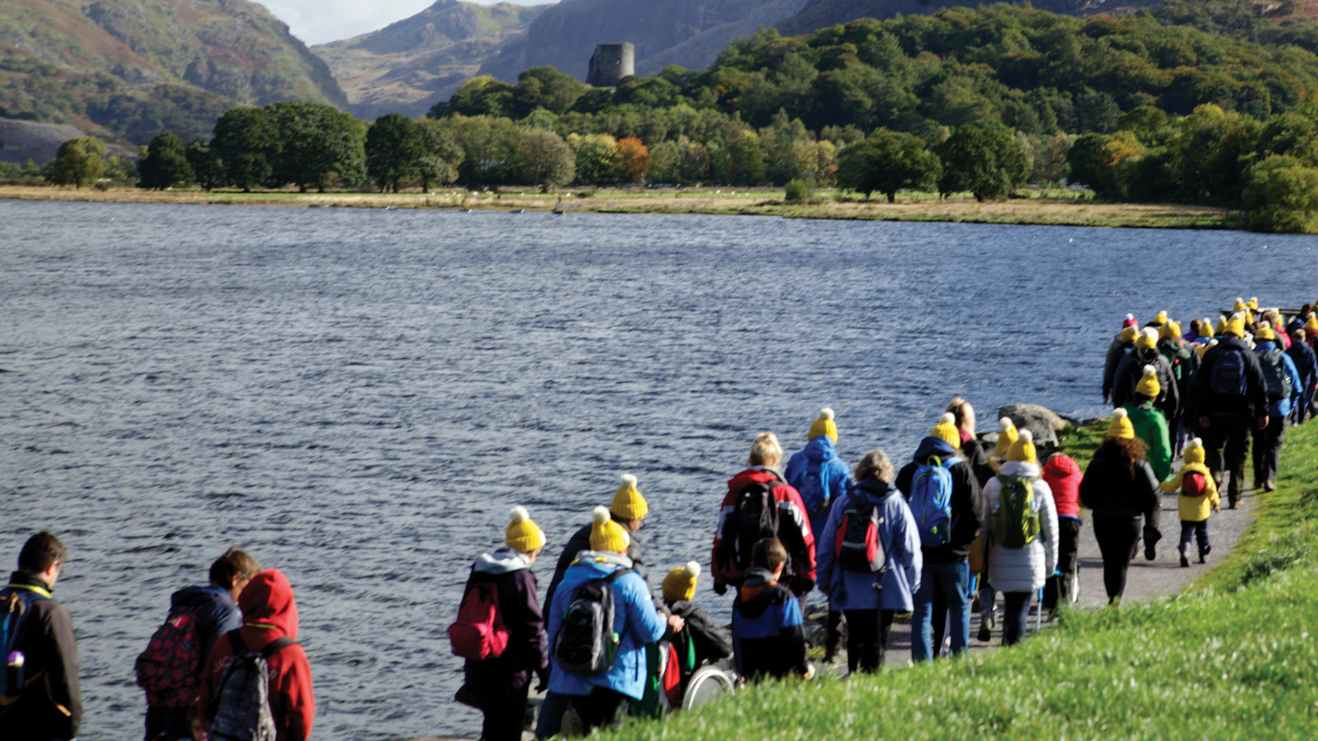 A group of people on a Countryfile Ramble by a mountain lake in Wales.