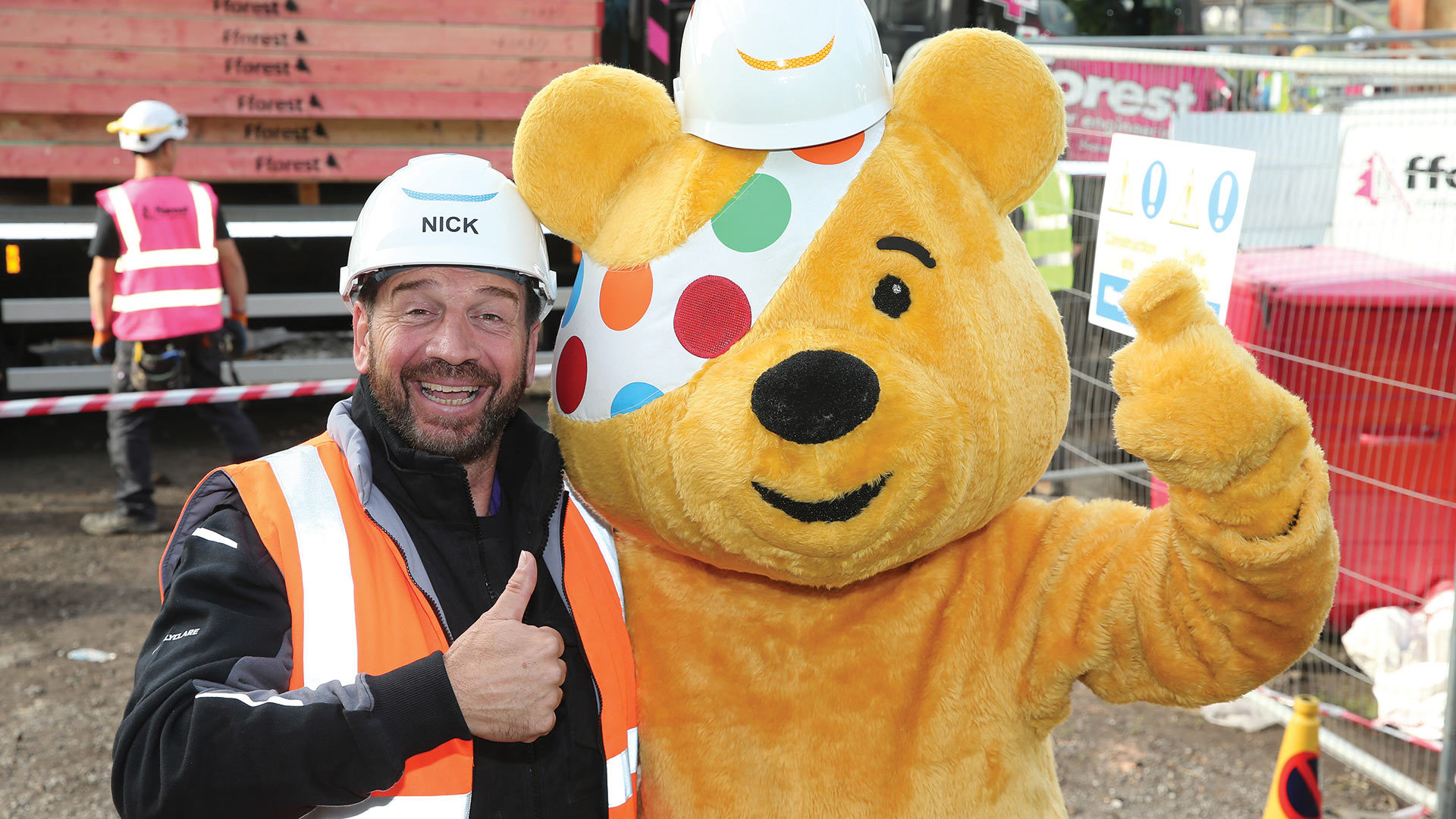 Picture of Nick Knowles with hard hat and arm around Pudsey for DIY SOS.