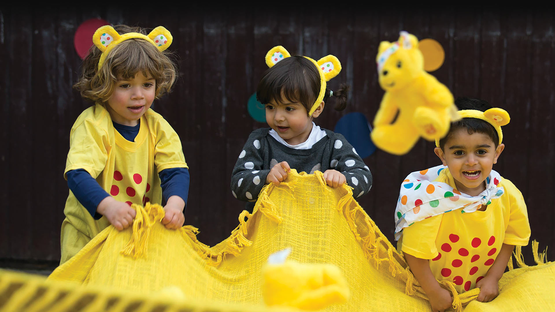 Children making a Pudsey toy bounce in a blanket