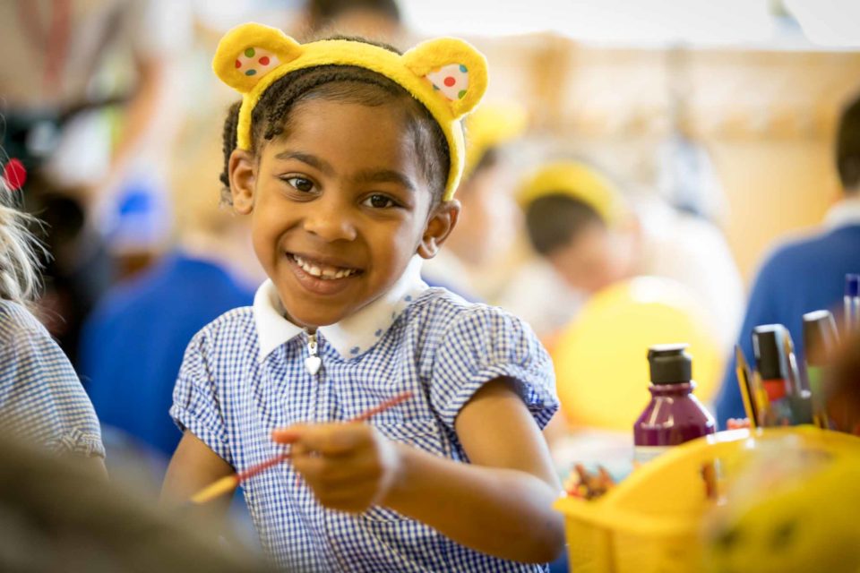 Little girl in Pudsey ears painitng