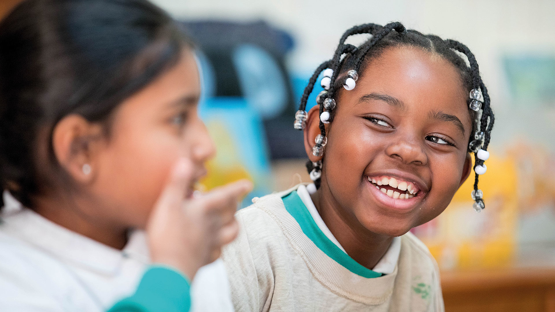 Two young girls laughing in a painting class