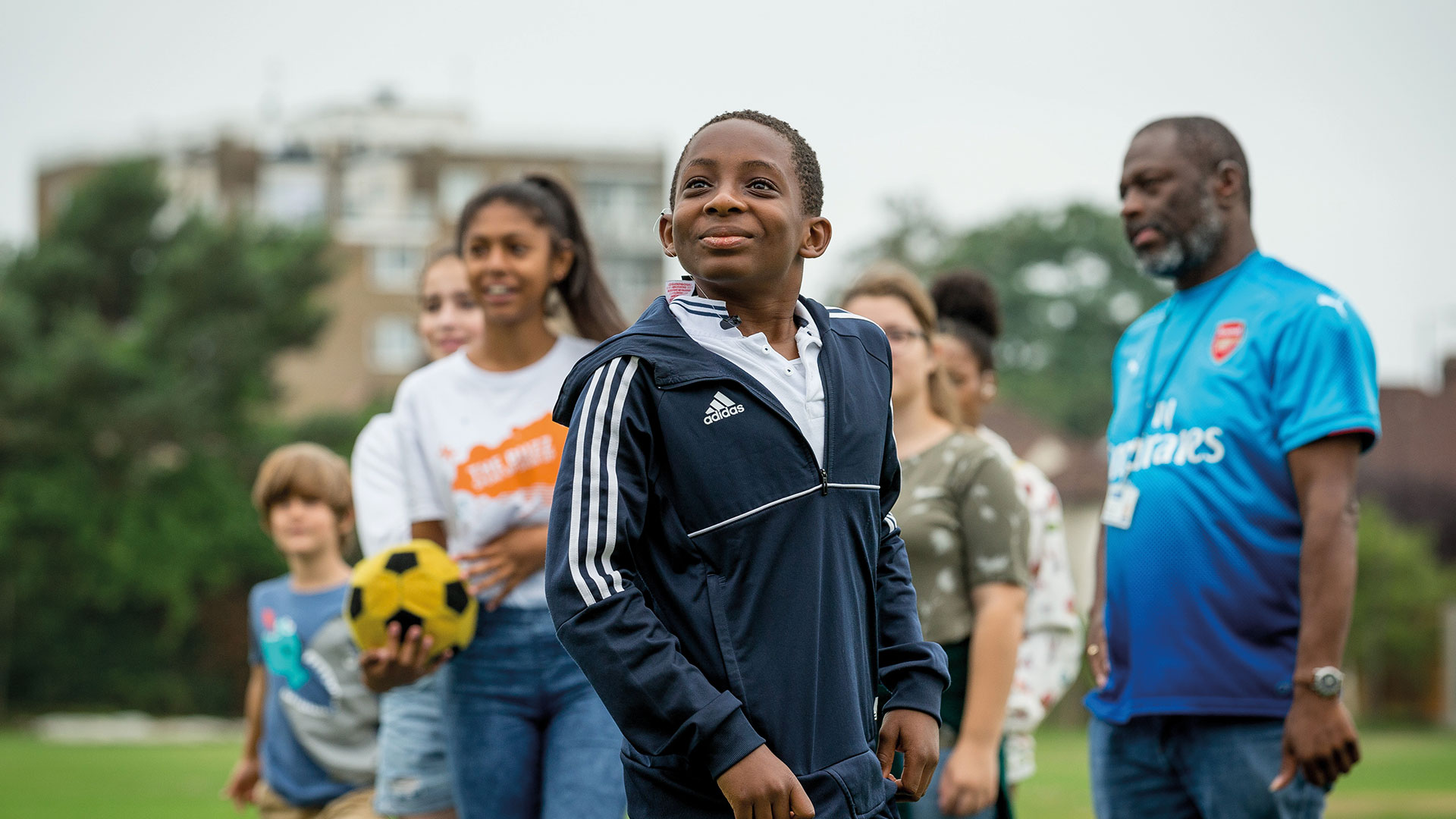 Group of children with a football and their coach