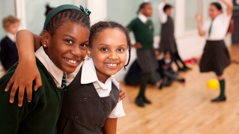 two school girls arm in arm