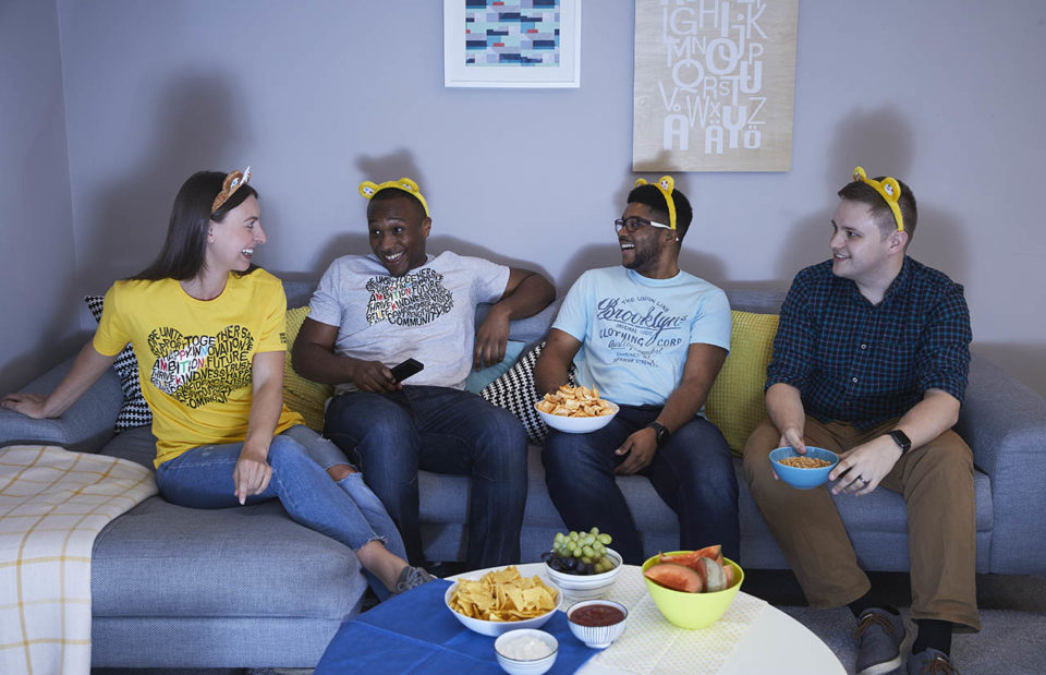 A group of young adults sit on the sofa wearing Pudsey ears and Children in Need t shirts enjoying our appeal show