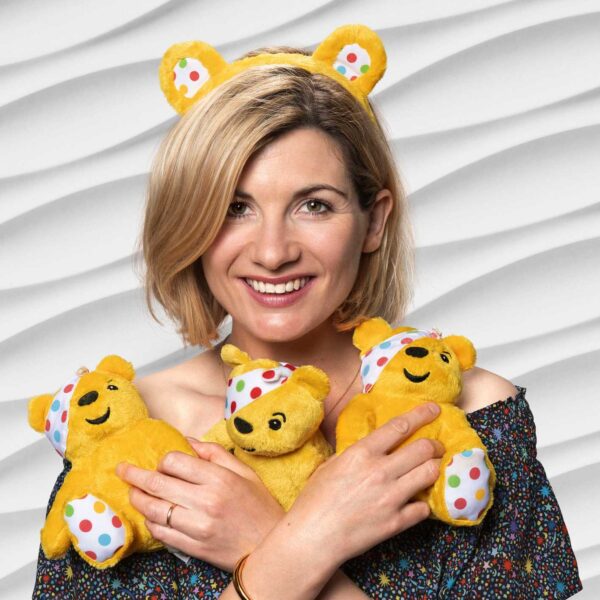 Jodie Whittaker holding three small Pudsey toys