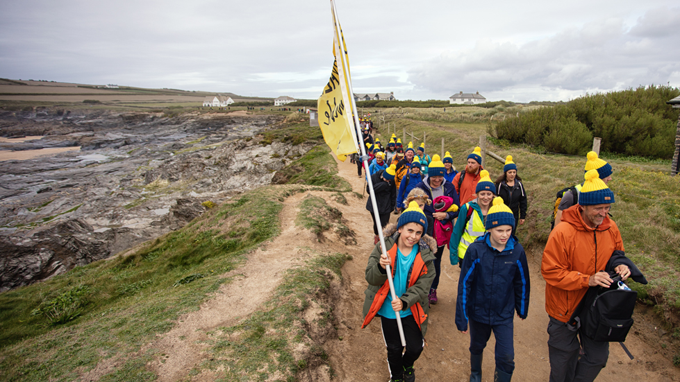 People walking through the countryside holding a Countryfile flag