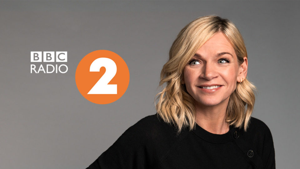 Zoe Ball smiling next to the radio 2 logo