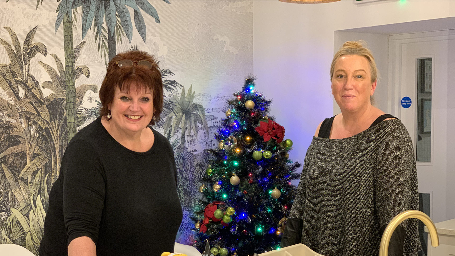 Two project workers from Nightsafe beside the Christmas tree they have put up