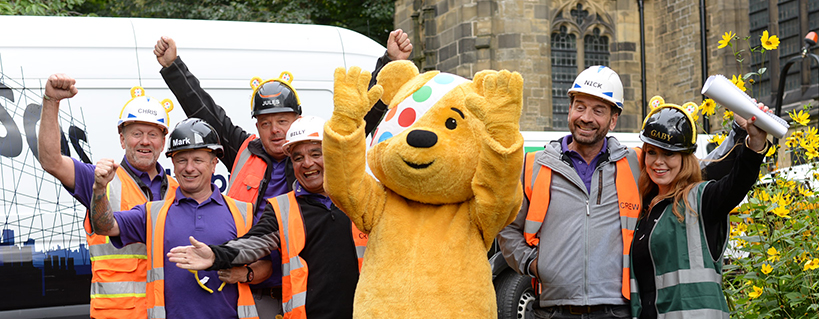 Nick Knowles, Pudsey and the DIYSOS team cheer outside a renovated property
