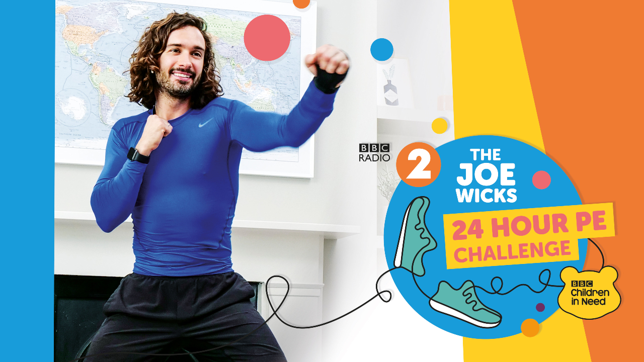 Joe Wicks punching the air in a workout outfit