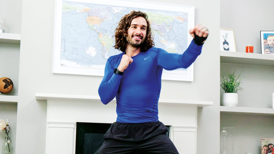 Joe Wicks Punching the air in a workout outfit