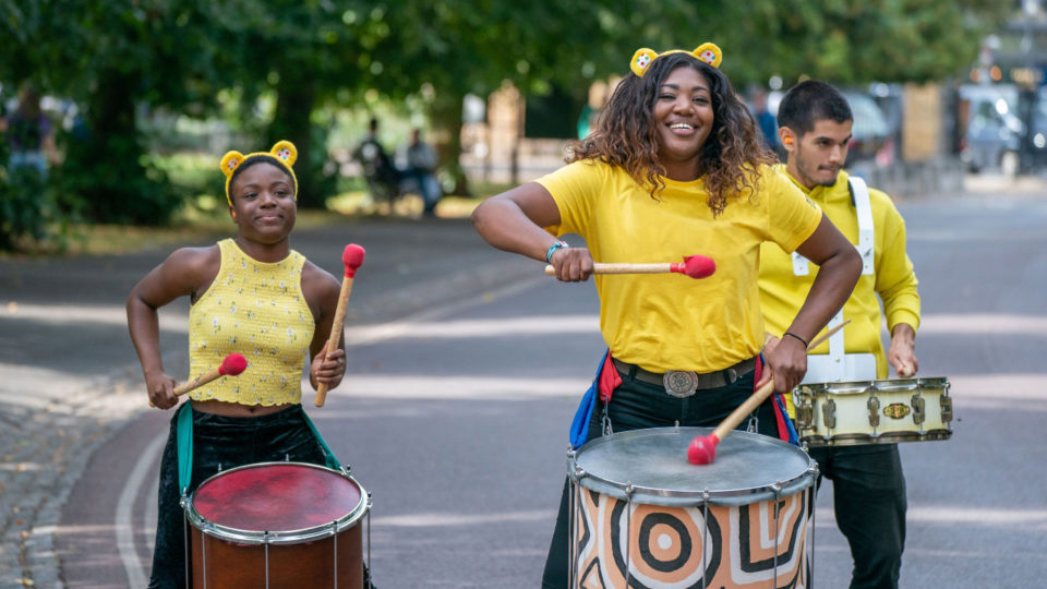 fundraisers wearing yellow t-shirts and banging drums