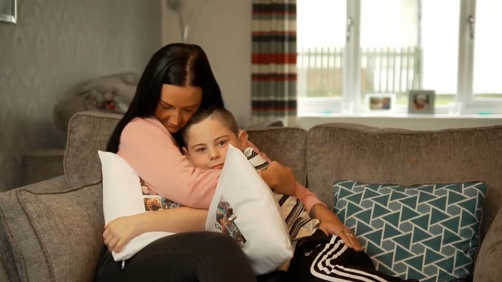 Nathan cuddling on the sofa with his Mum