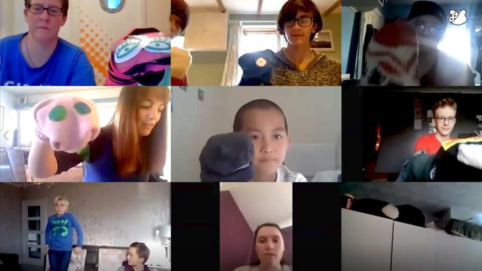 A zoom call filled with adults and children using homemade sock puppets
