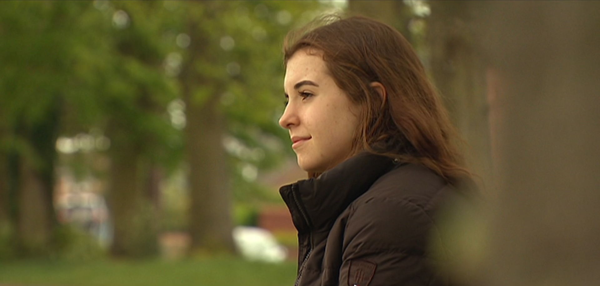 Emily in a park looking into the distance