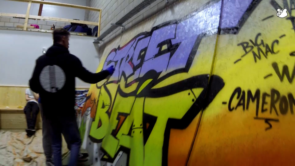 A graffiti artist painting on a wall