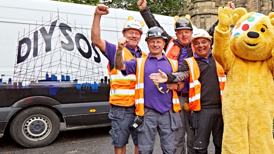 The DIY SOS team cheering with Pudsey Bear