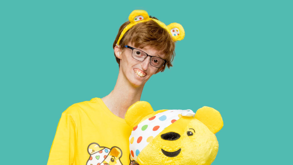 Dylan hlding a pudsey bear toy adn wearing ears