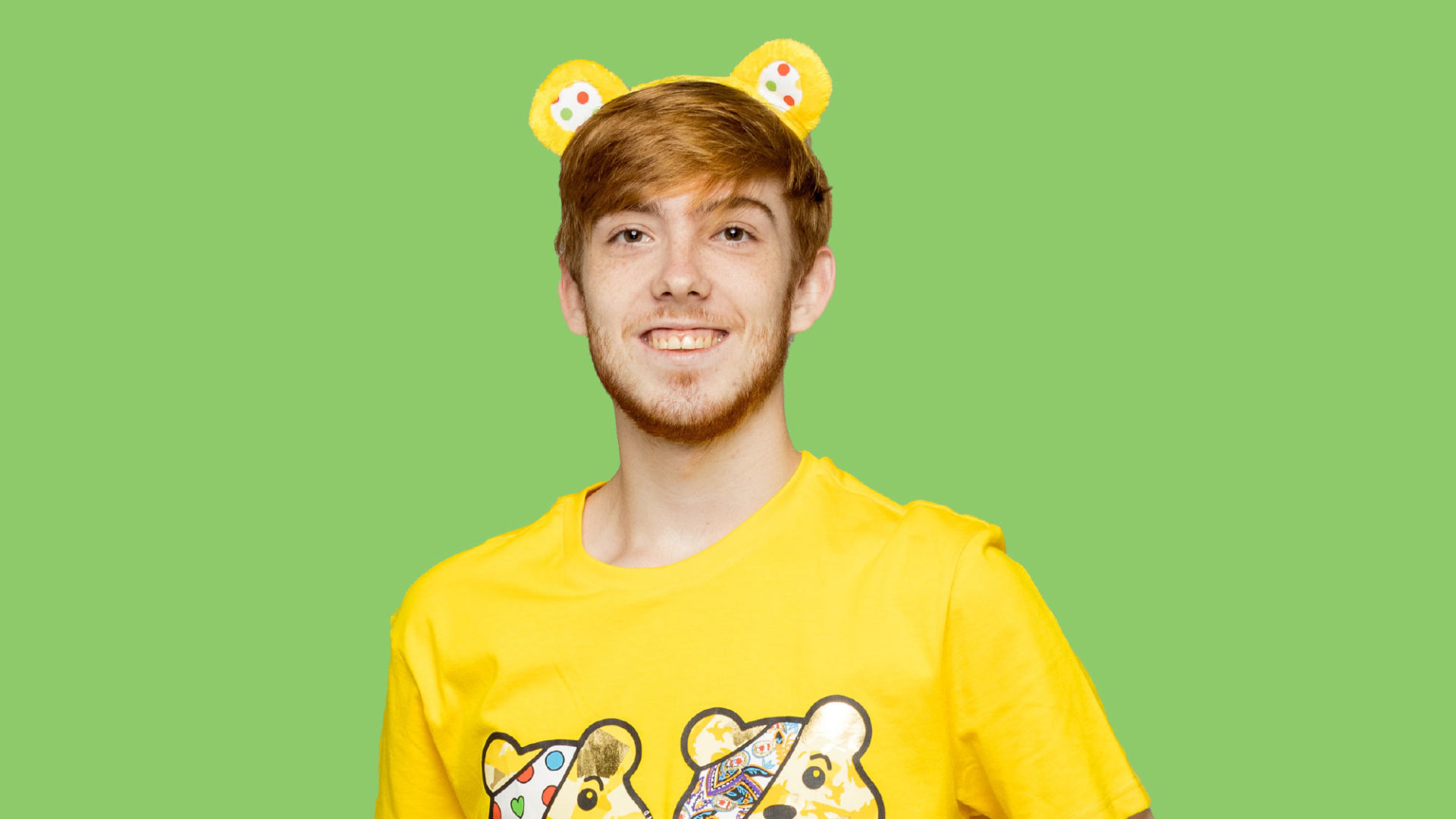 Joe holding a pudsey bear toy and wearing pudsey ears
