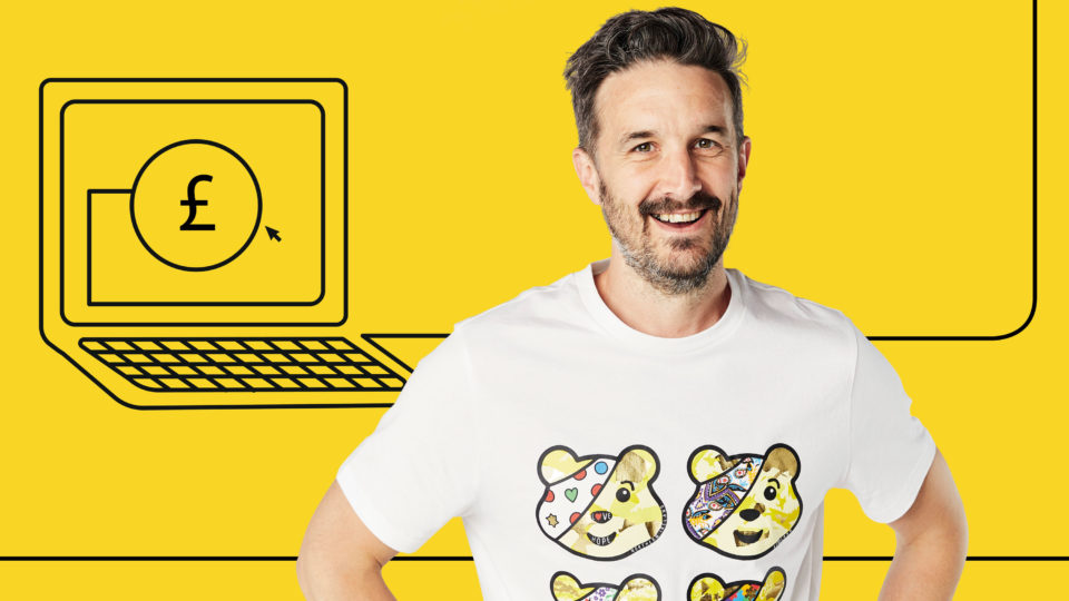 A man in a pudsey t-shirt with an illustrated laptop
