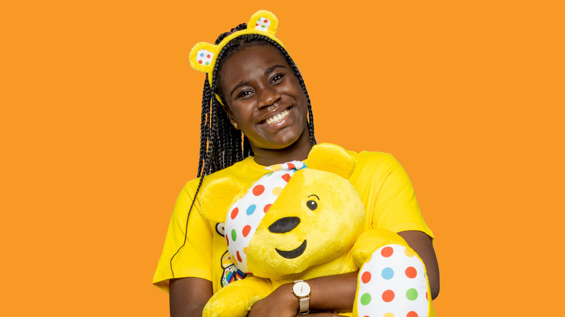 Ore holding a pudsey bear toy and wearing pudsey ears