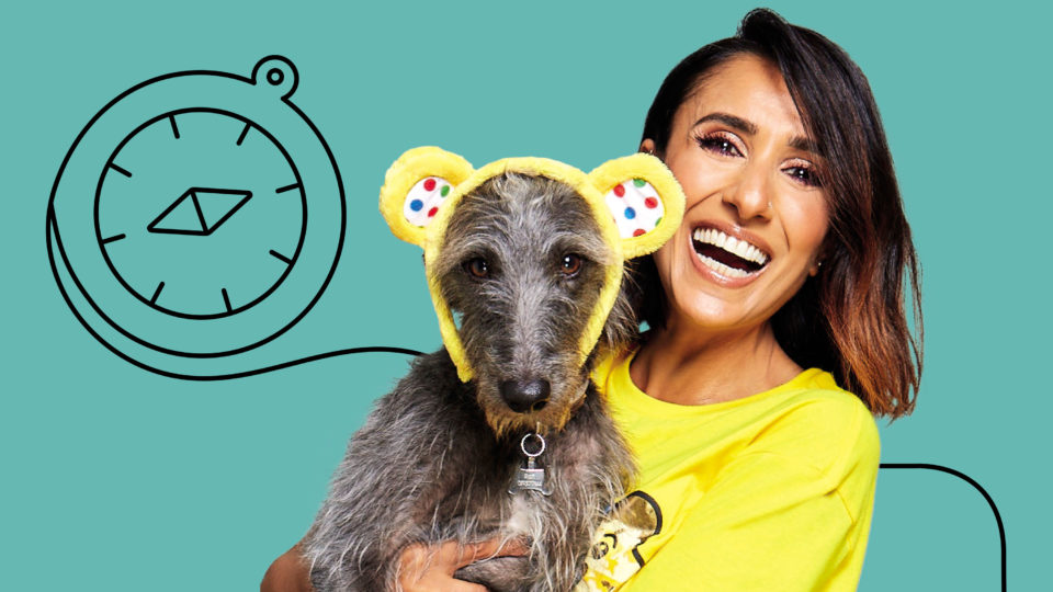 a lady holding a dog wearing pudsey ears and an illustrated compass