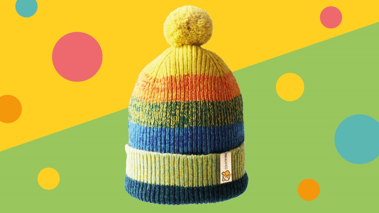 A multi coloured wool hat with a yellow bobble