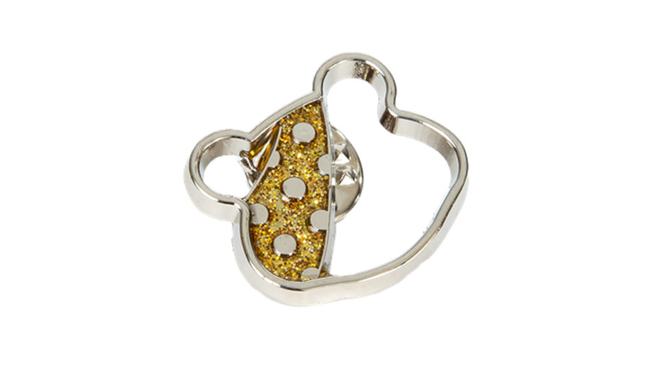 A silver Pudsey pin badge with sparkly gold bandana