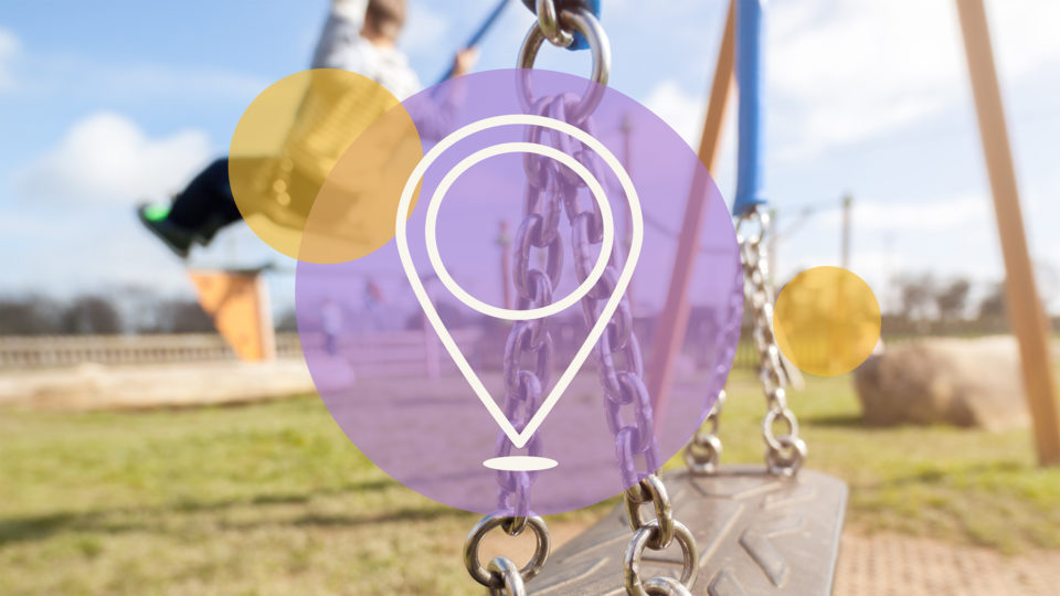 An icon of an online map pin in front of a picture of a playground