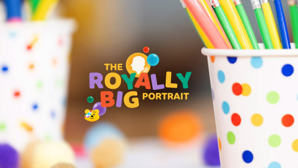 Spotty pots of crayons and multi coloured lettering staying 'The Royally Big Portrait' with a picture of Pudsey's head