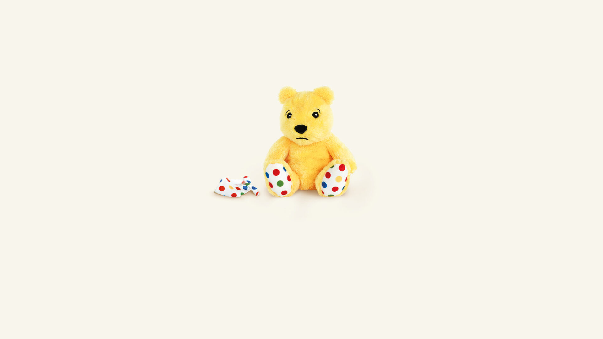 Pudsey Bear looking sad with his Bandana on the floor next to him