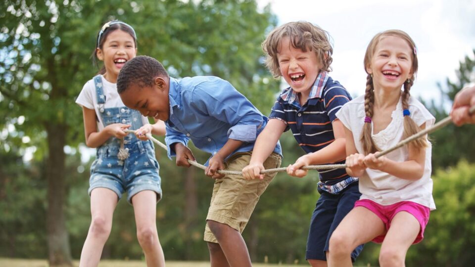 children laughing whilst playing tug of war