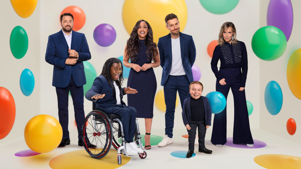 The BBC Children in Need presenters arranged in front of a volourful spotty background
