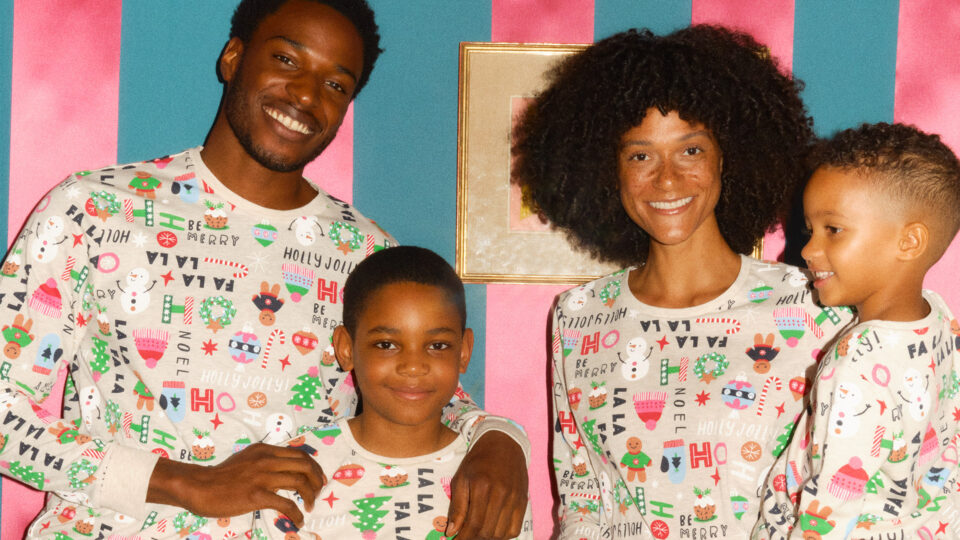 A family wearing christmas pajamas featuring Pudsey