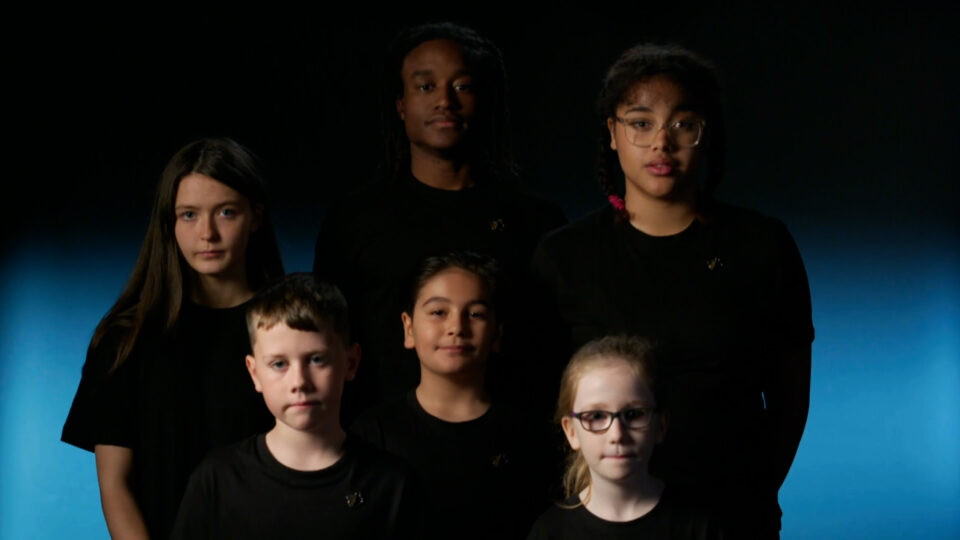 A group of children wearing black t-shirts