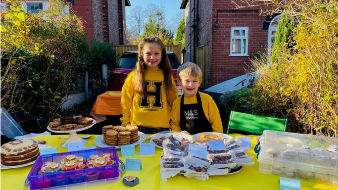 Libby and Harvey in front of a table of baked goods