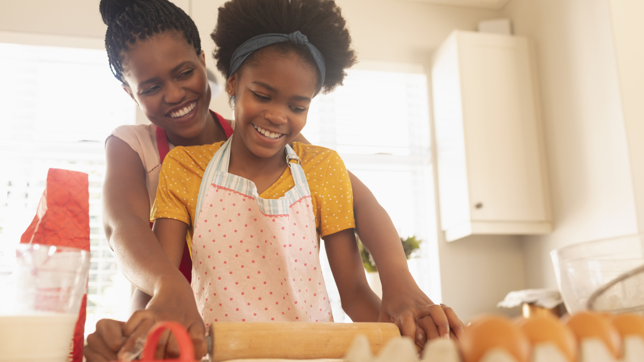 A mum and daughter baking together in a kitchen