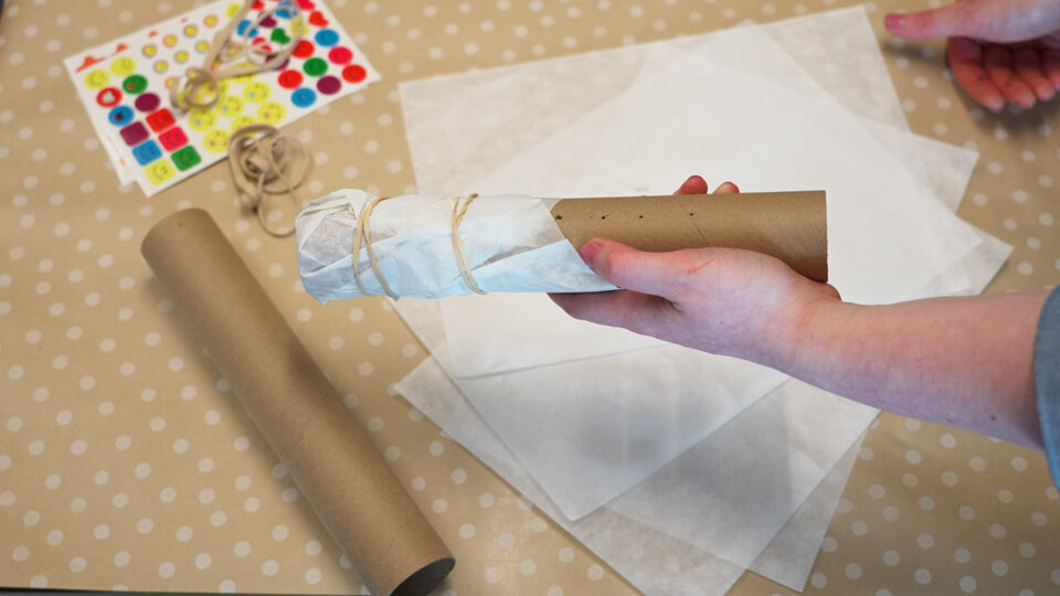 A toilet roll tube being turned into a homemade kazoo