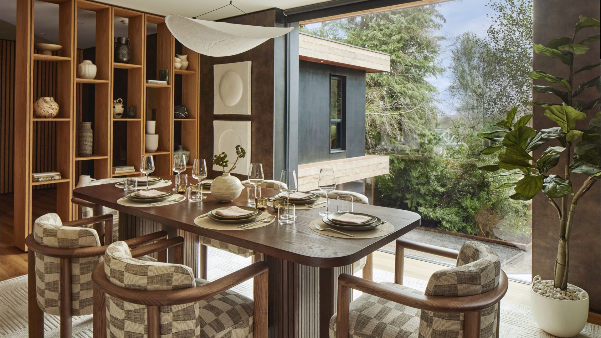 A dining room with a large window view out to a forest