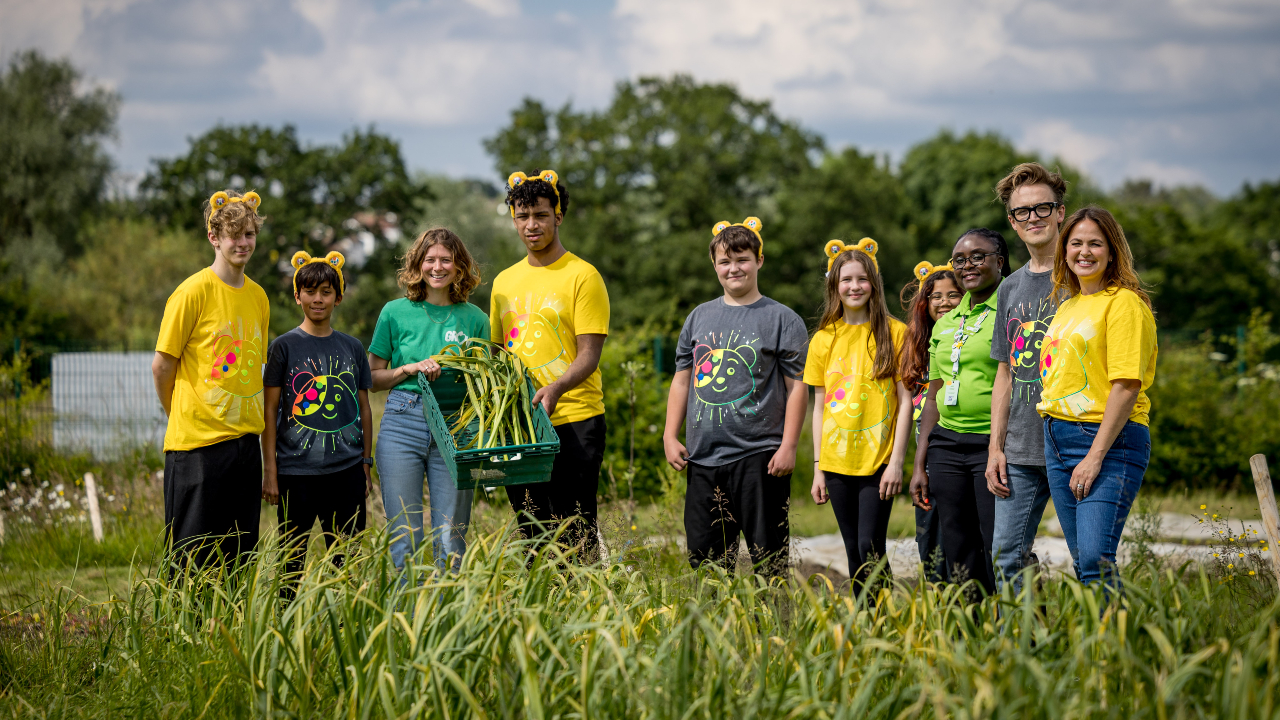 Tom and Giovanna Fletcher in a field with children from the GROW project