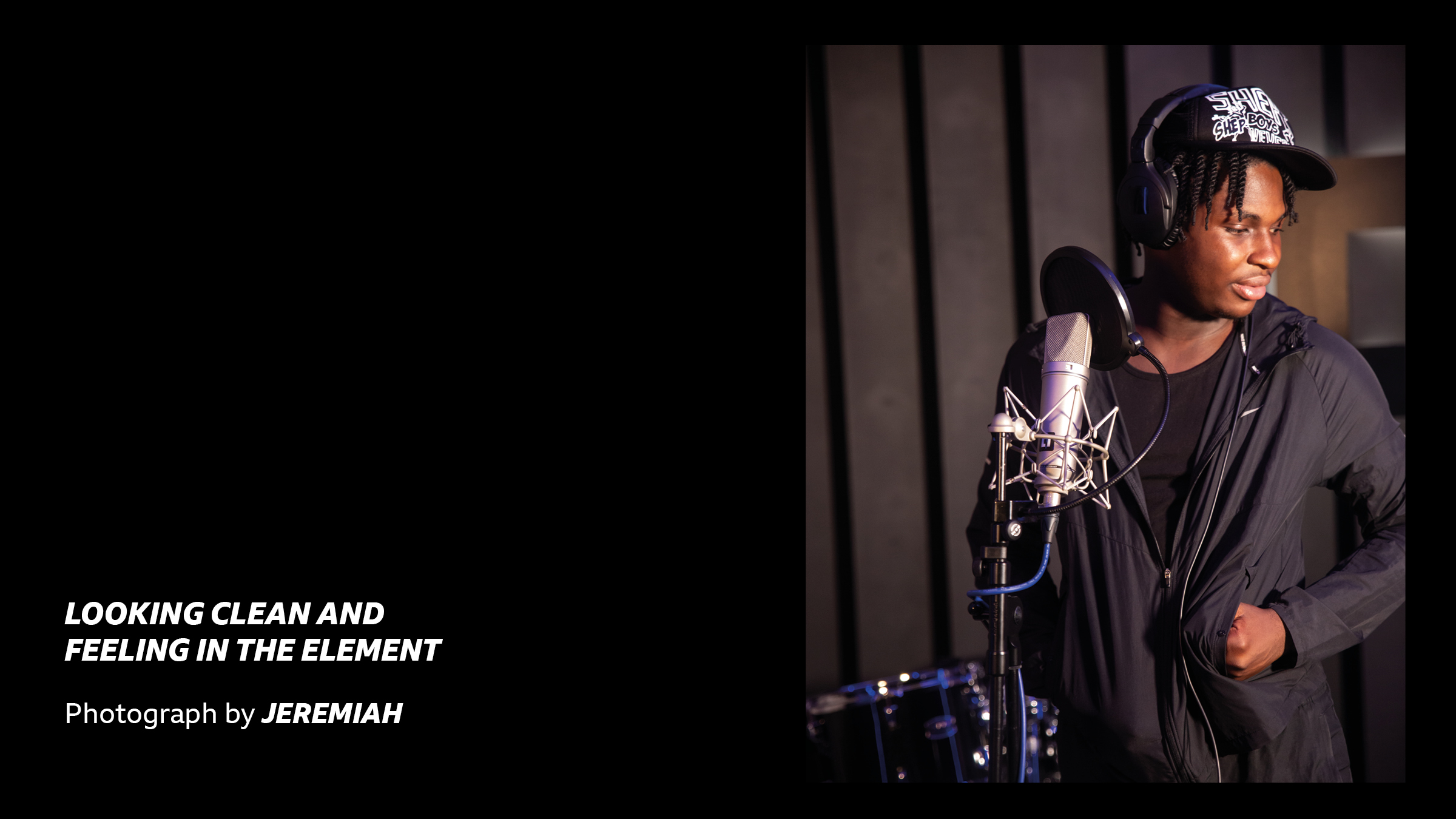 'Looking clean and feeling in the element - Photograph by Jeremiah' - A young person thinking next to a microphone in a low lit studio