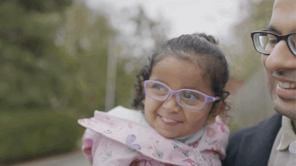 A smiling girl with purple glasses