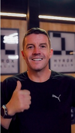 A man in sports clothes giving a thumbs up gesture