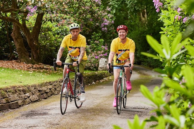 two people cycling in yellow t-shirts