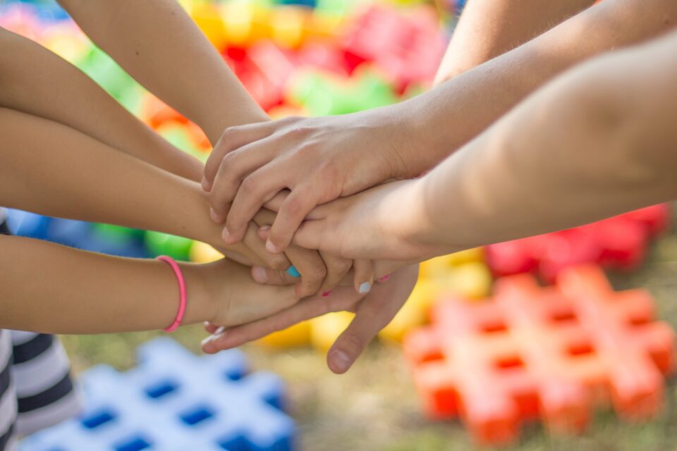 A group of young children putting their hands together