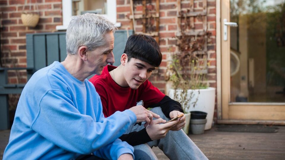 An adult sat down and talking to a young person