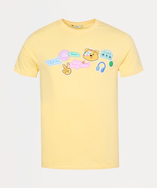 A yellow t shirt with various symbols on the front including Pudsey Bear, headphones and a hand holding up two fingers in the peace sign
